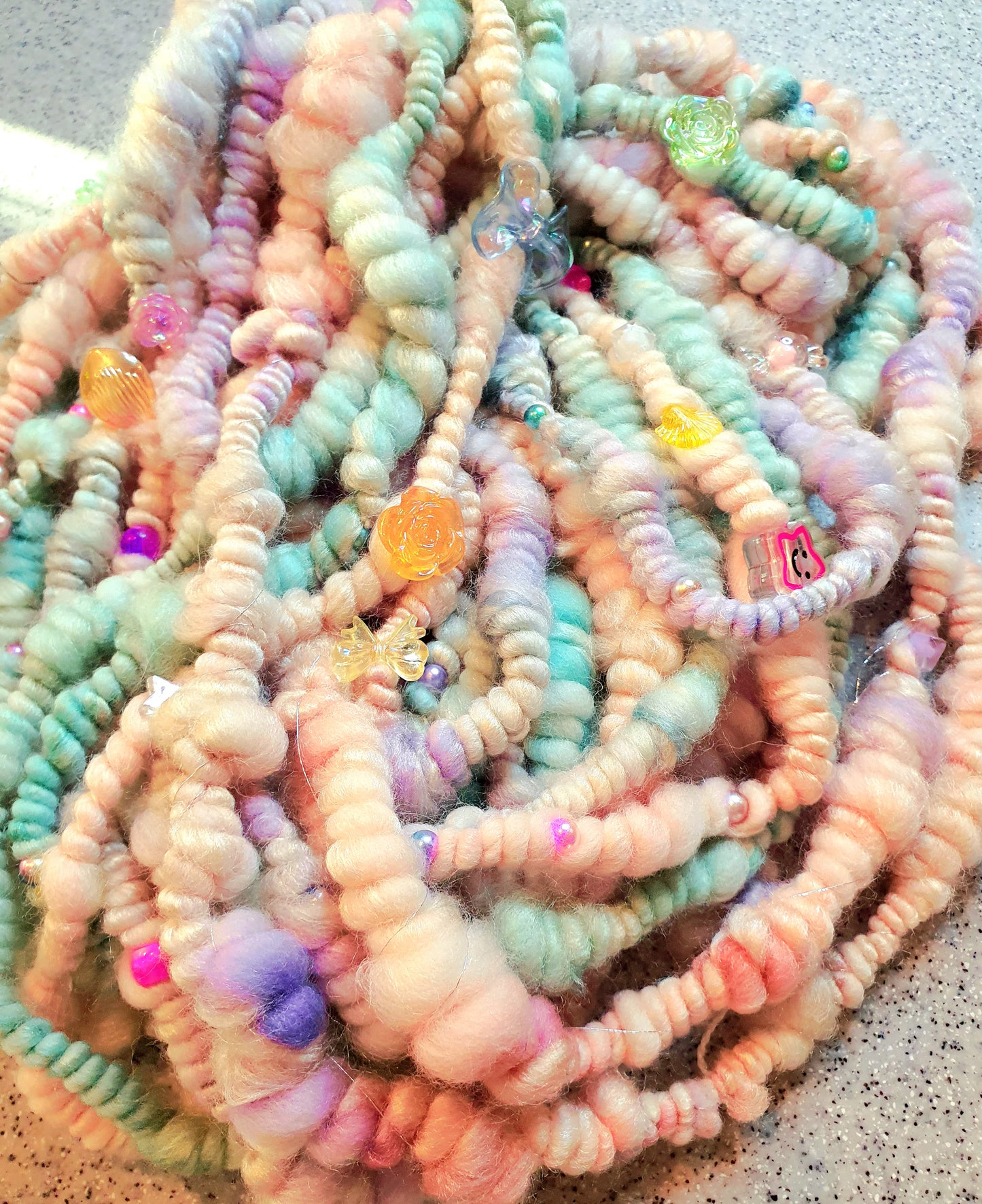 Beaded mermaid art yarn. Handspun art yarn in unicorn/mermaid colours.