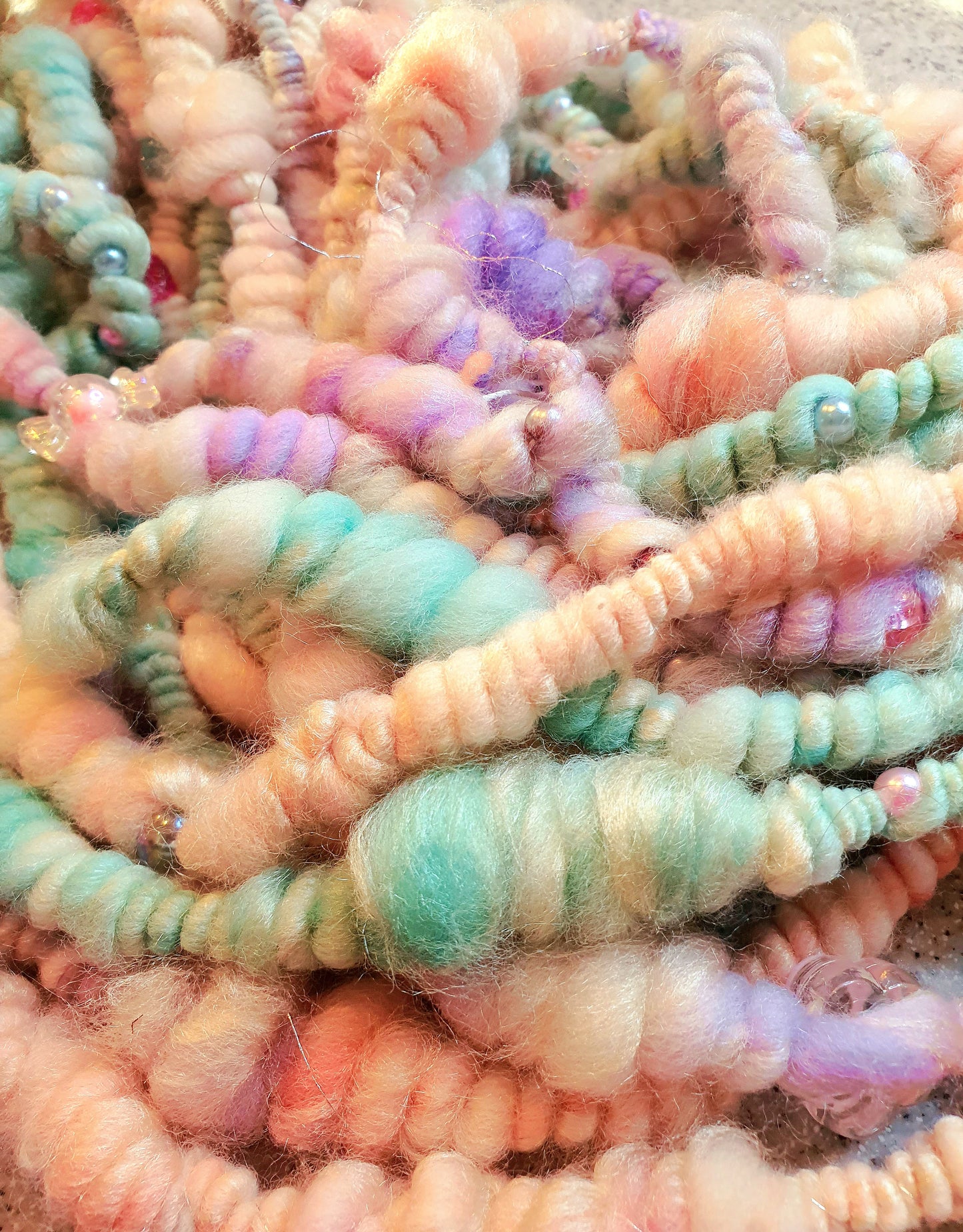 Beaded mermaid art yarn. Handspun art yarn in unicorn/mermaid colours.